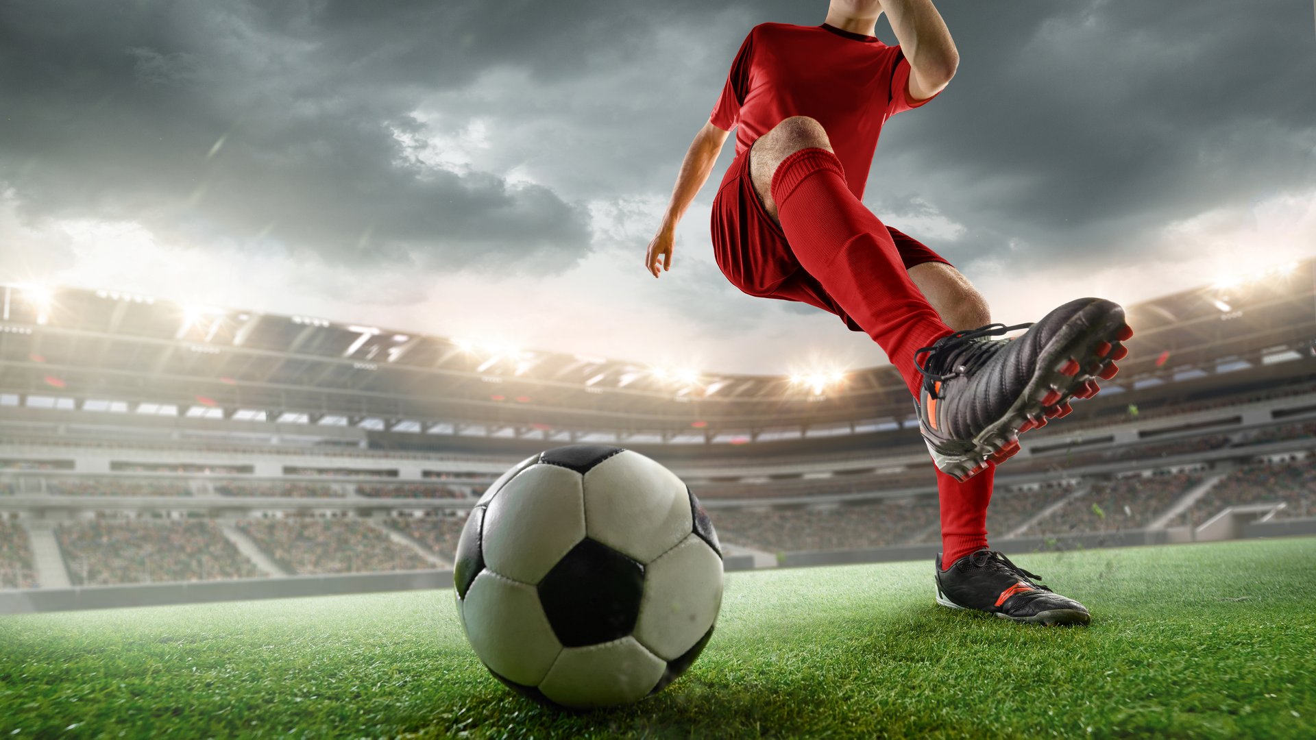 Cropped image of soccer player in red uniform during intense outdoor game, kicking ball against stormy sky. 3D render of stadium. Concept of sport, competition, tournament, dynamic action, power.  Composite image