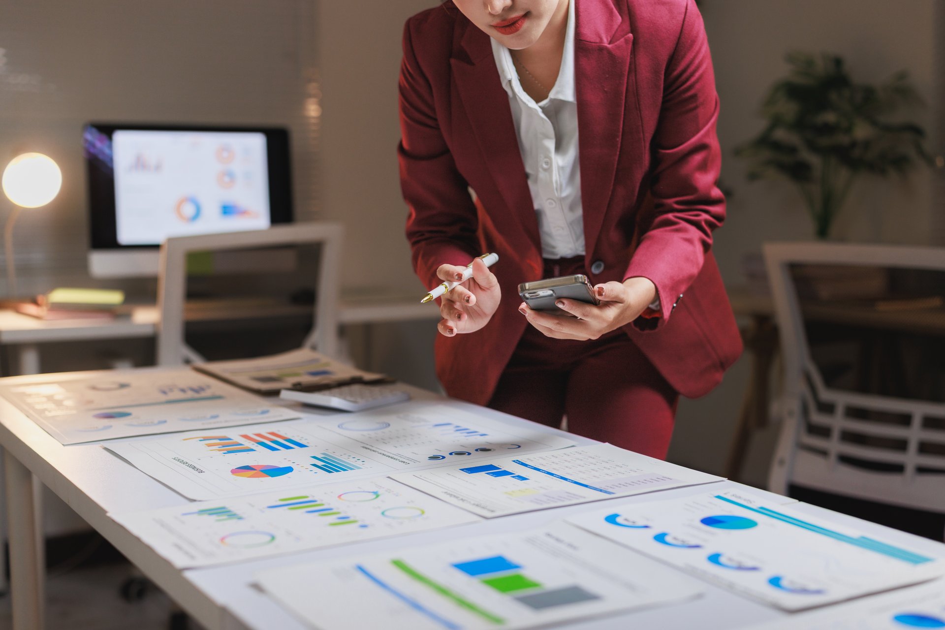 Donna d'affari analizza report finanziari e dati sullo smartphone, strategie digital marketing