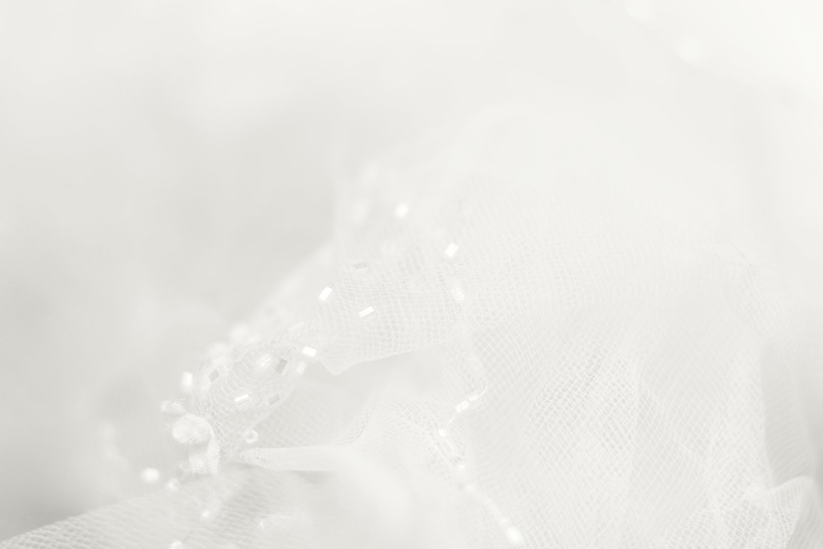 Delicate cloud white dancer tulle background. Blurred wedding veil with beads. Demonstrating color, trend 2026 year.