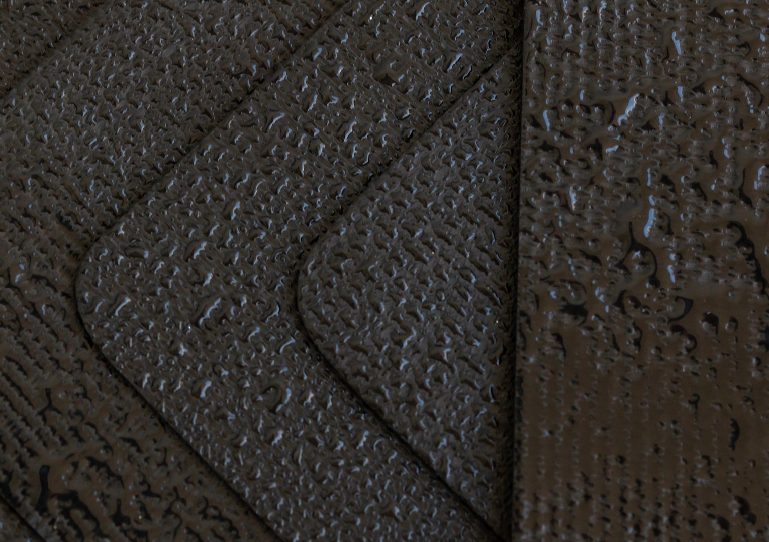 Water droplets on EPDM rubber membrane. Close-up, selected focus.