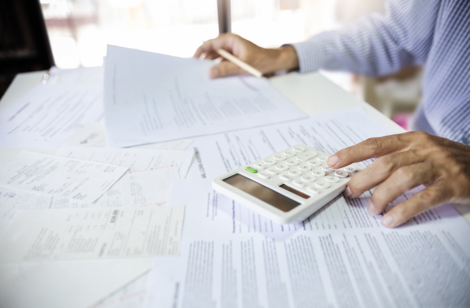 Close-up shot. asian men hand using calculator to calculate expenses and tax to recive tax reduction for personal individual Income. tax return concept for individual person