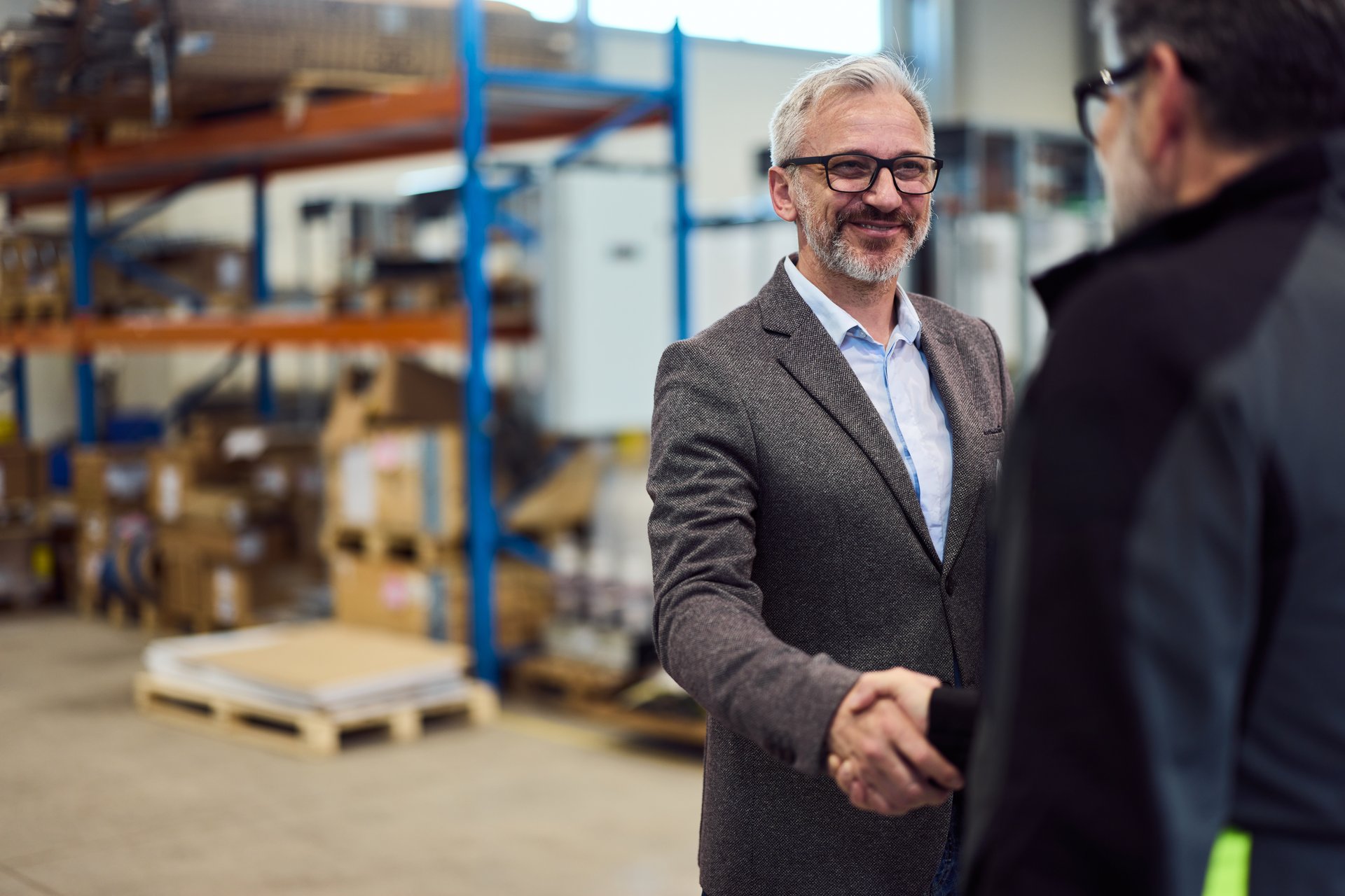Two men exchanging a handshake in a business setting, showcasing partnership and teamwork