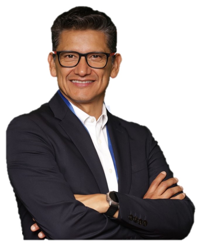 Person with glasses in a suit, smiling with arms crossed against a white background.