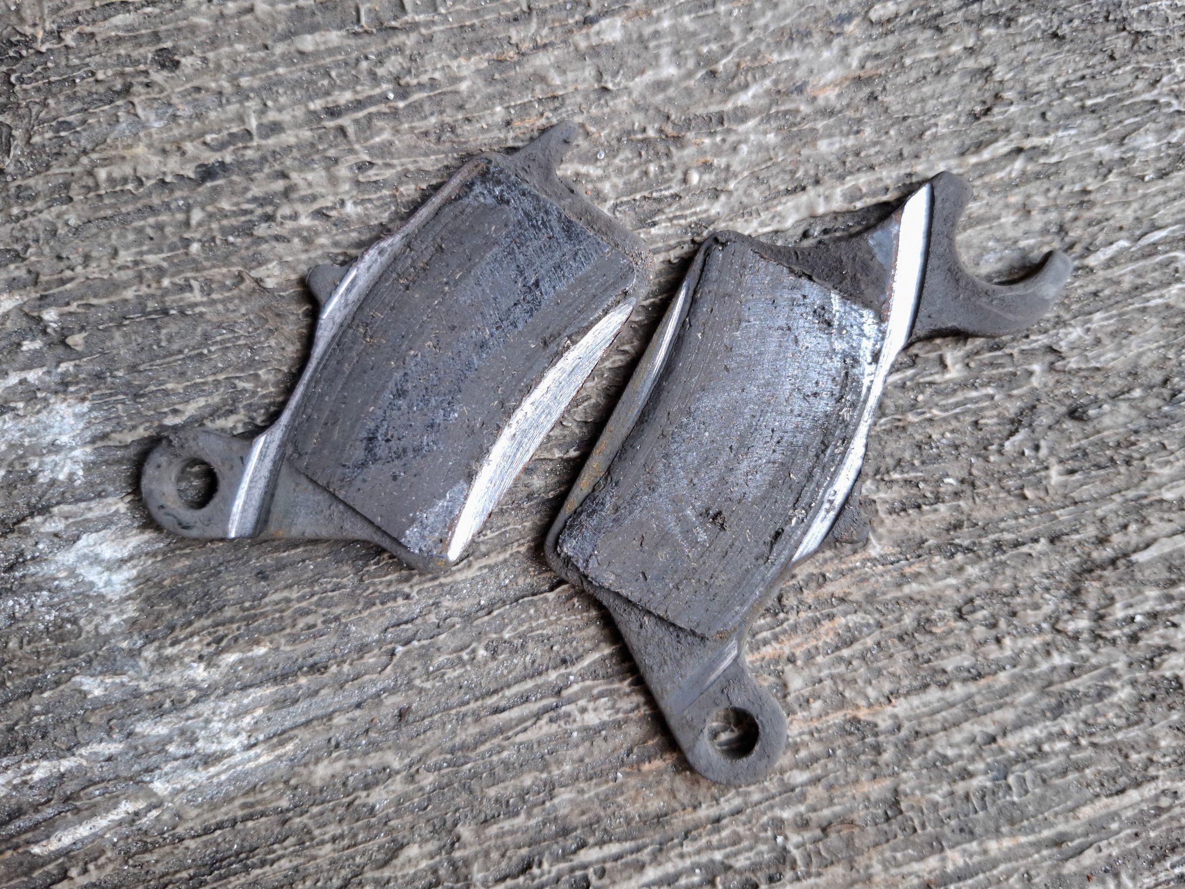 Motorcycle disc brake linings that are damaged due to use. brake failure concept