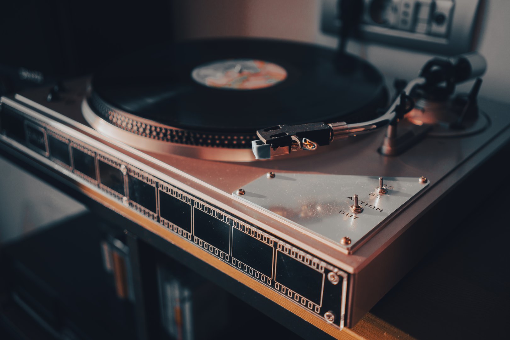 Details of a modern record player on the table, an interesting light on the side.
