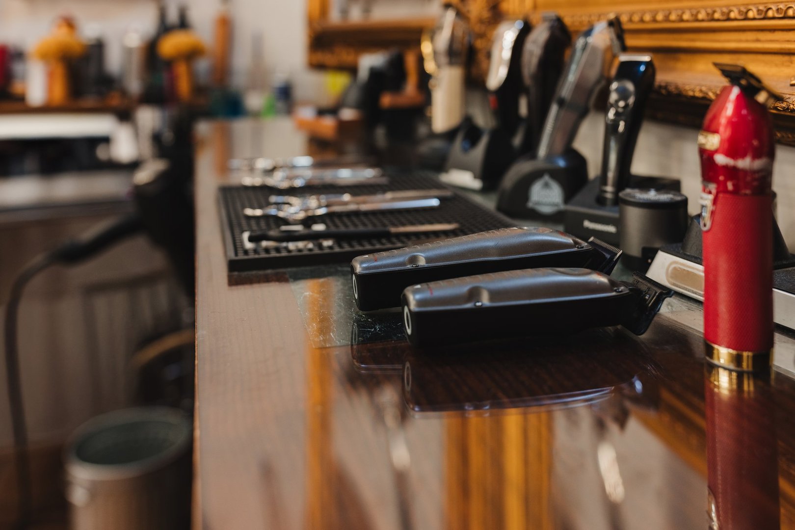 A barber shop with a red bottle of hair spray on the counter. The barber shop is well organized with all the necessary tools and equipment