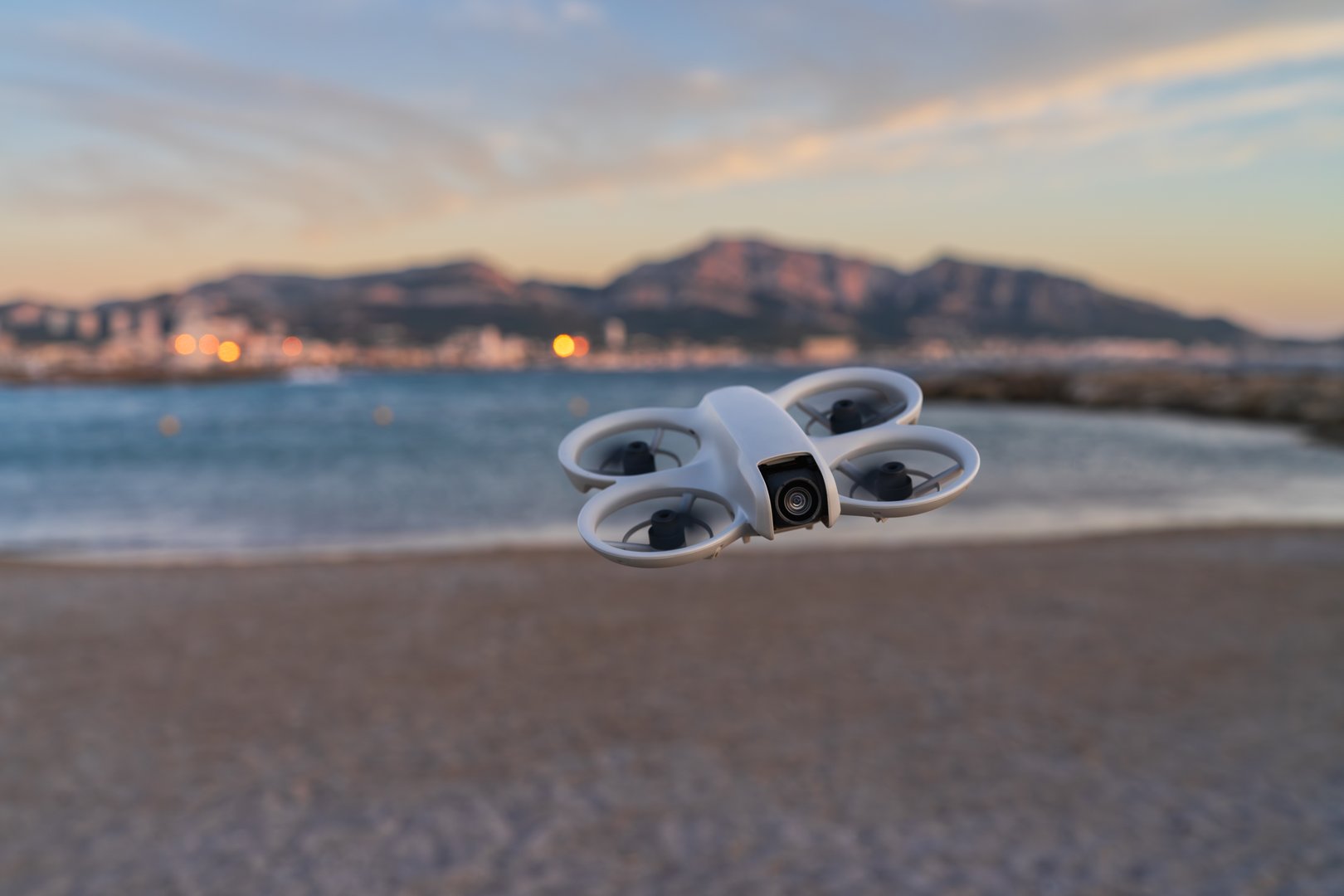 A modern FPV drone flies capturing cinematic aerial views
