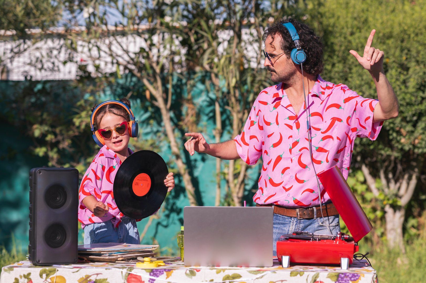 Father and daughter having fun playing djs at a summer party in the garden