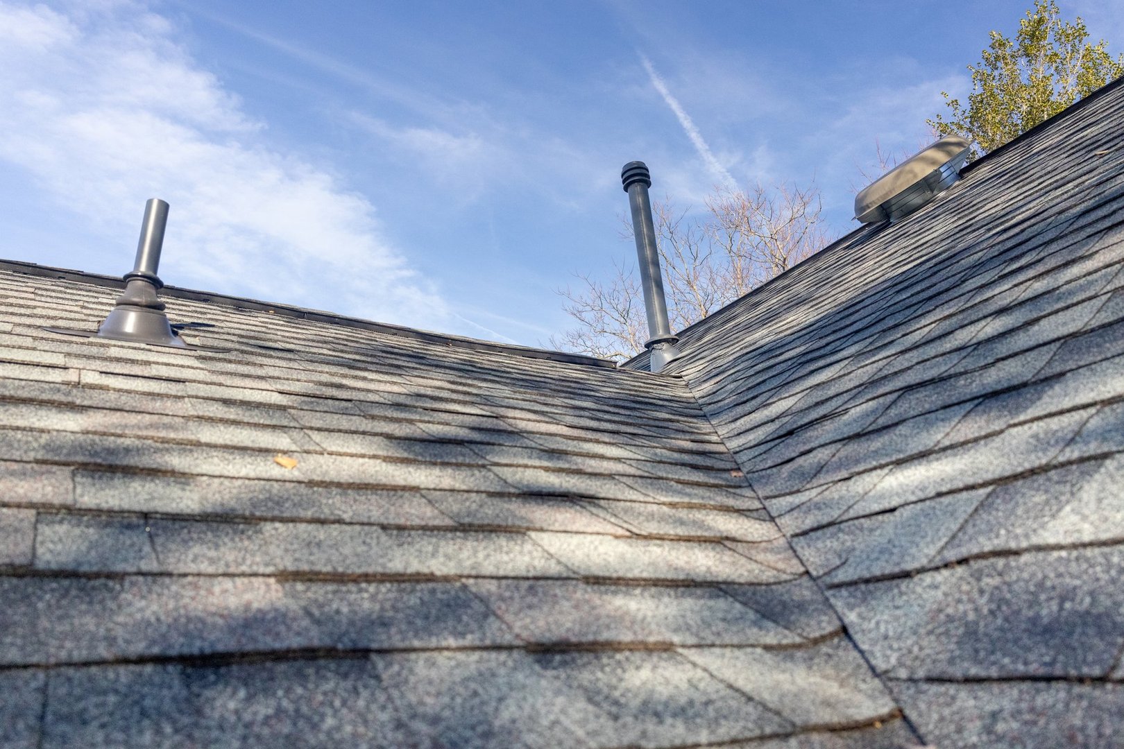 Problem area on roof with chimney and exhaust ports through asphalt shingles