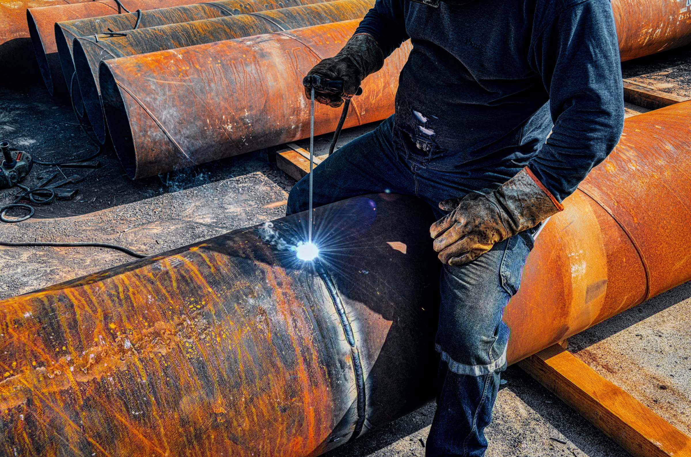 Master welder and protective equipment performing pipe welding