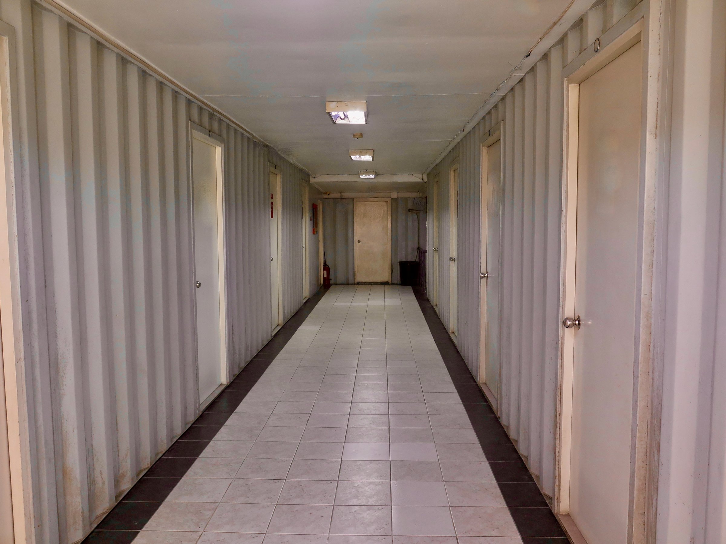 Long corridor in a hotel. Symmetrical hallway showing industrial geometry lines.