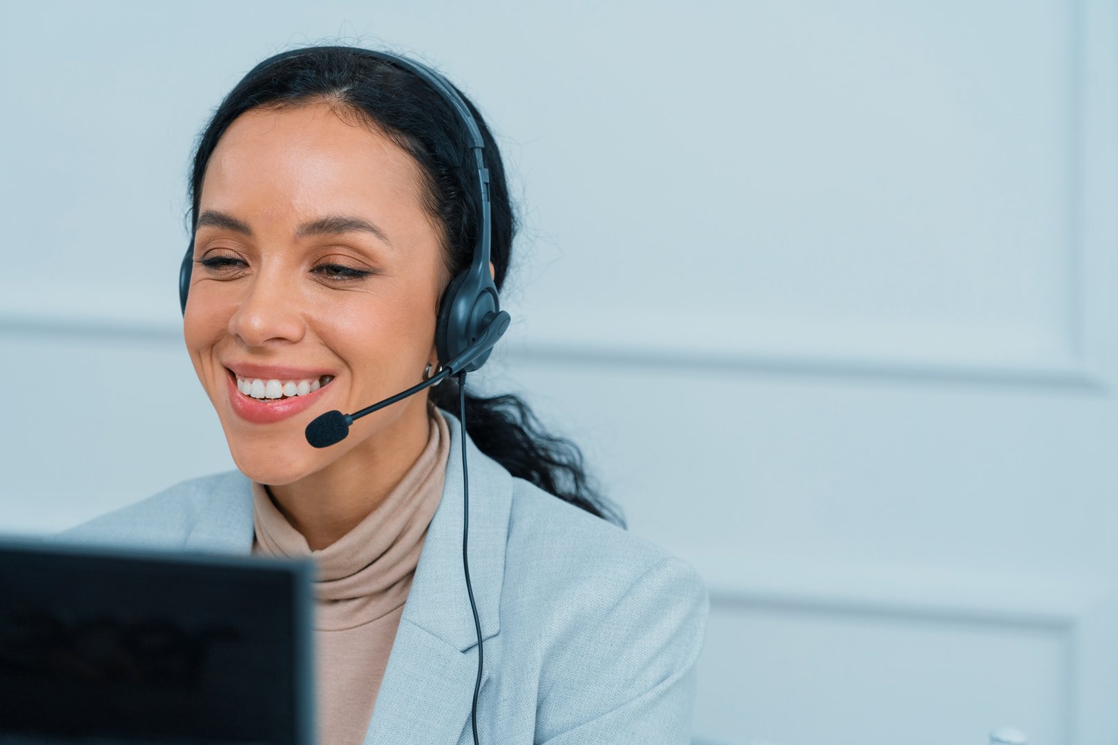 African American businesswoman wearing headset working in office to support remote crucial customer or colleague. Call center, telemarketing, customer support agent provide service on video call.