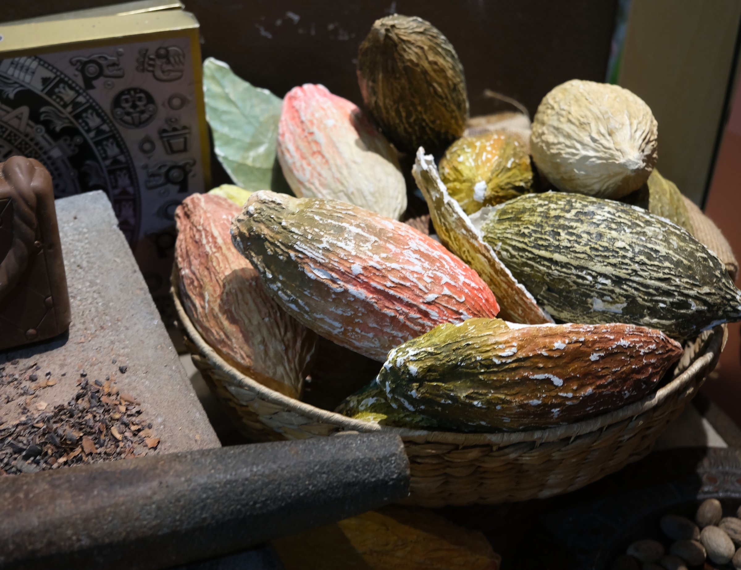 Traditional chocolate-making tools and ingredients, cocoa pods, beans, spices, beautifully arranged in a rustic, artisanal culinary setup. Close up of cocoa pods.