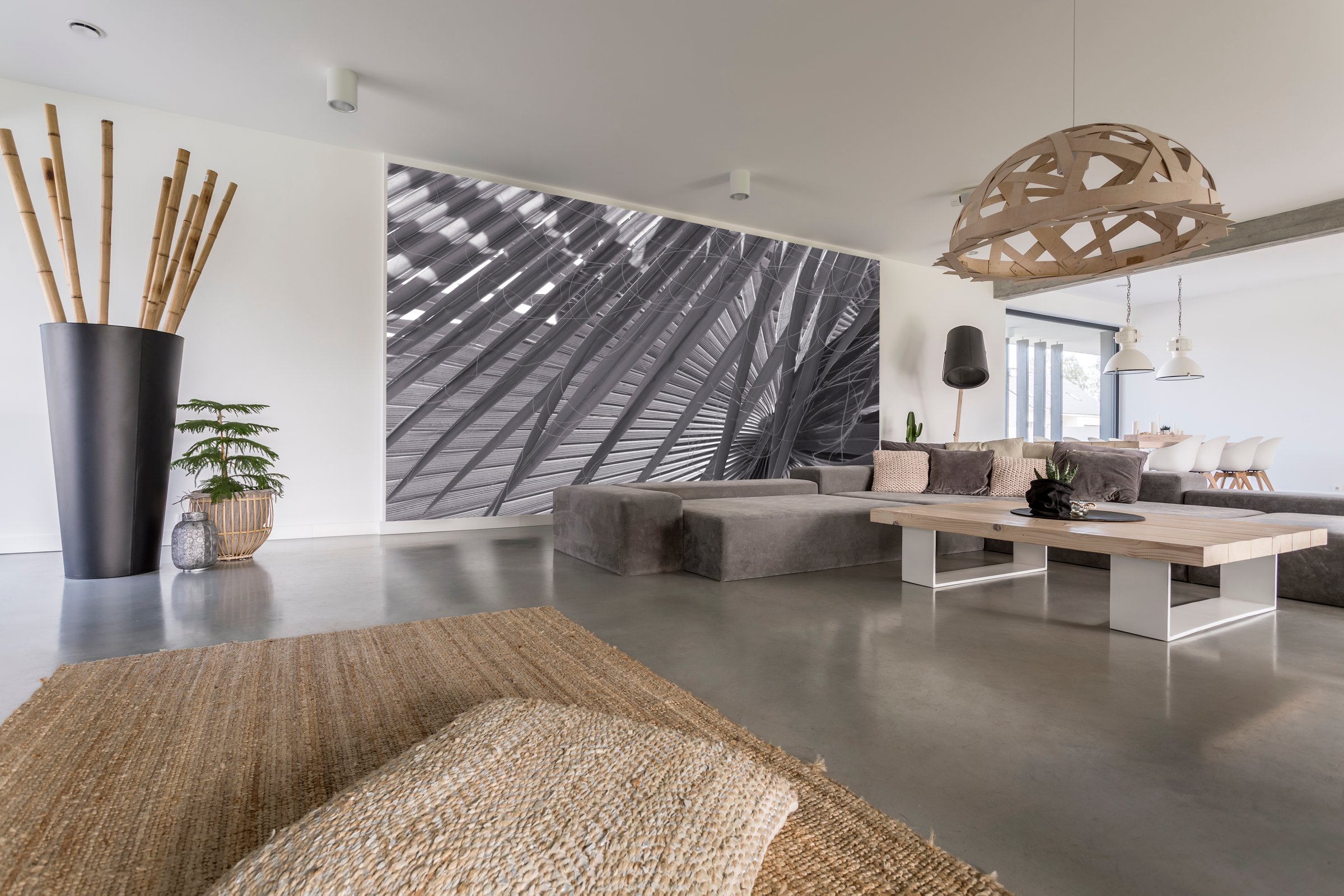 Decorative chandelier above designed table in living room with grey mural on wall
