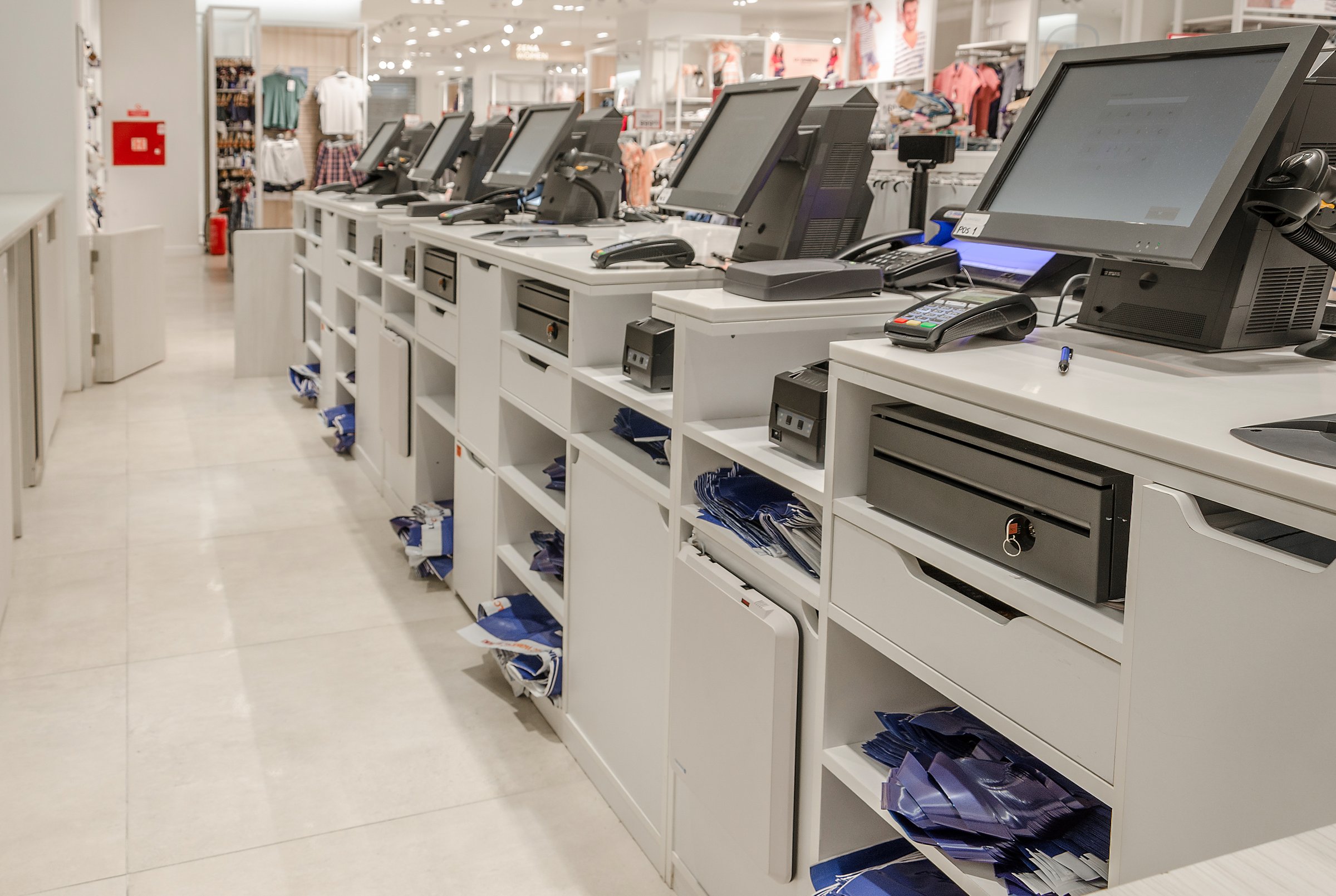 Electronic cash or modern cashier standing at the counter in a large empty store dressing room