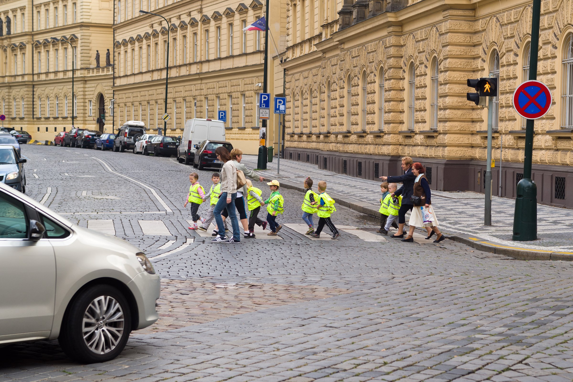 Prague, Czech Republic - September 9, 2014: Kindergardten children wearing yellow safety vests while crossing the street in Prague.