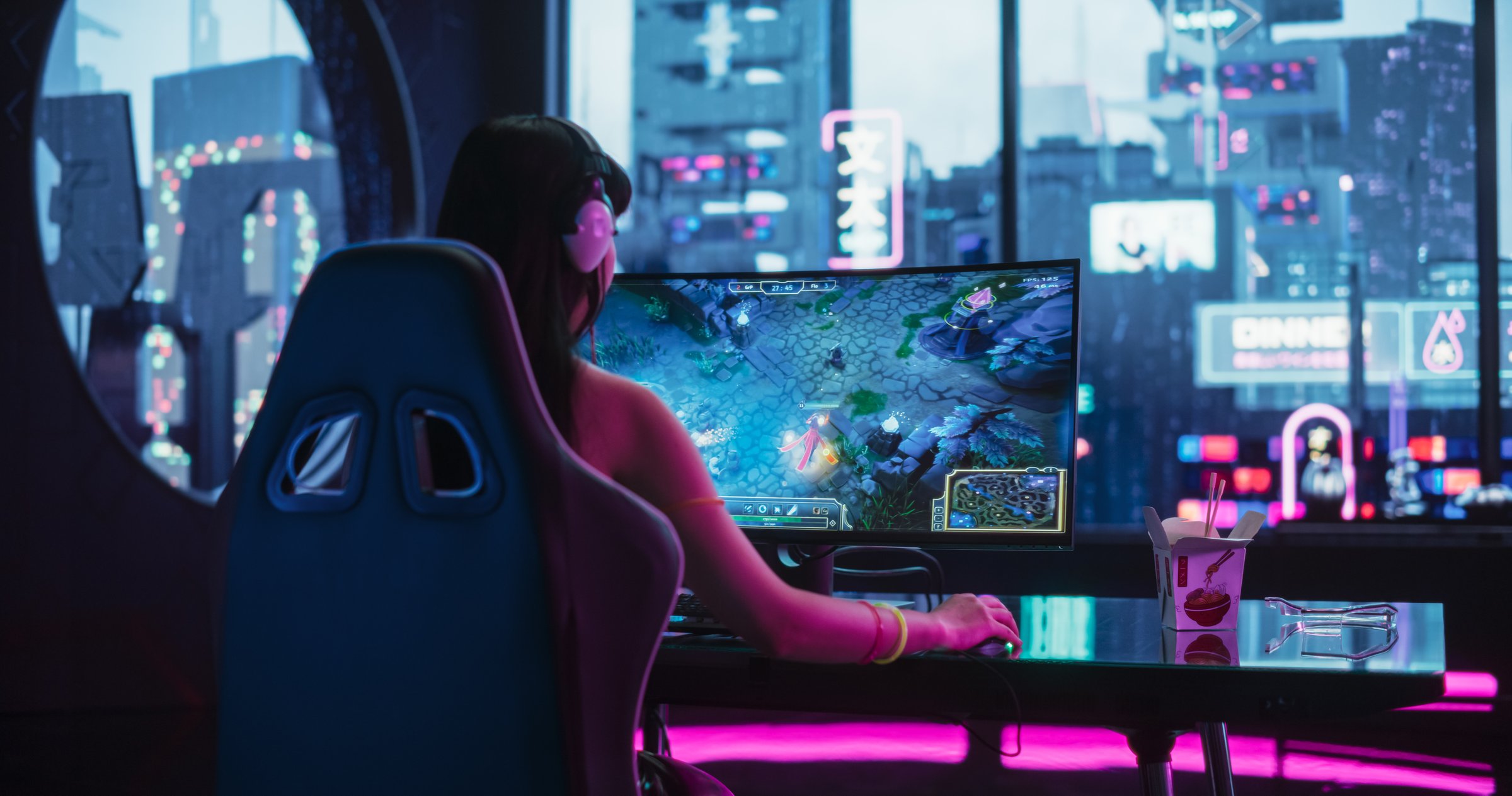 Young Woman Wearing Futuristic White Clothes and Neon Rings, Playing Online Strategy Video Game on a Computer with Curved Monitor. Beautiful Girl in Headphones Participating in an eSports Match