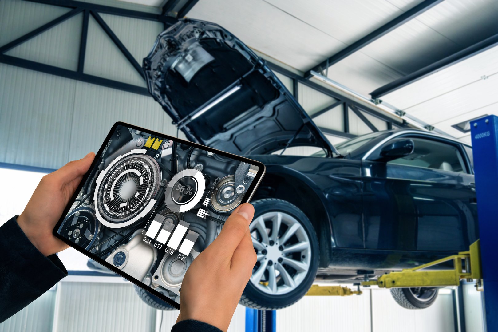 Serviceman with laptop checks engine in car service augmented reality.