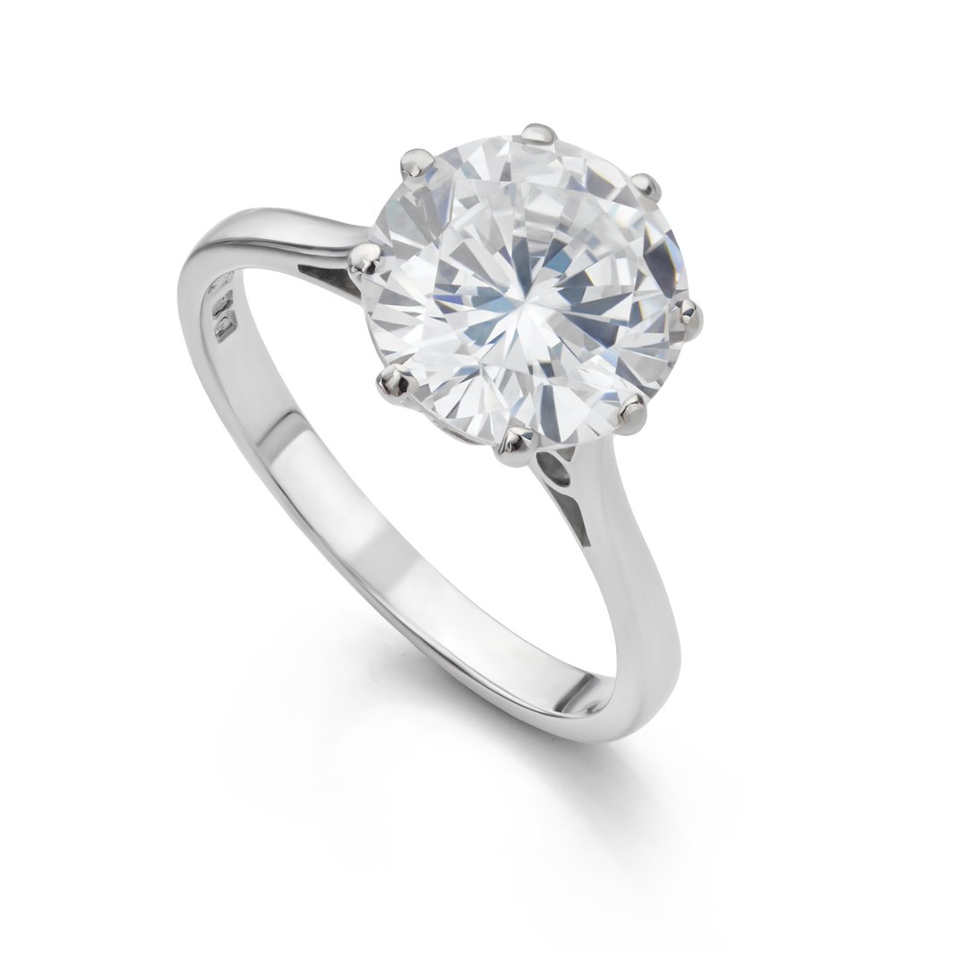 Large solitaire diamond engagement ring isolated on white background.