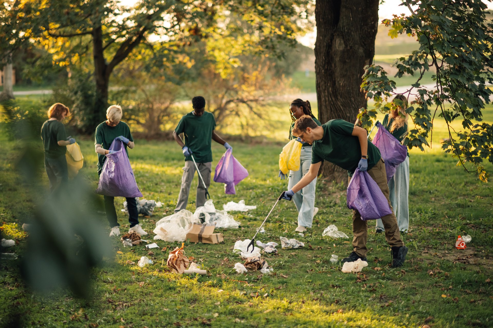 Volunteers clean up park, picking trash, promoting sustainability, teamwork, and responsibility for the earth. Raises awareness about pollution and recycling