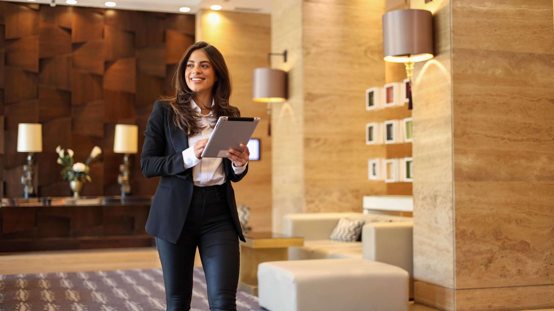 Beautiful, young businesswoman working on a tablet at the lobby of her company