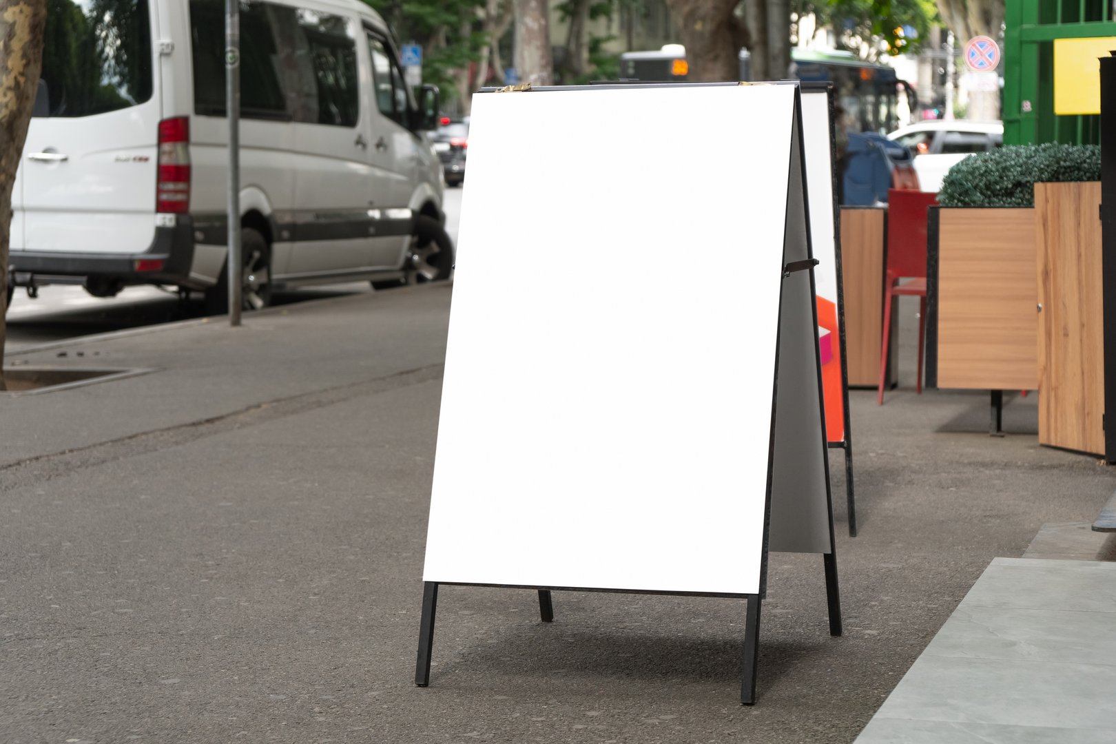 Side view of blank white sandwich board on a street. Portable folding billboard