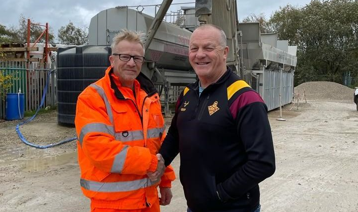 Smiling construction professionals exchanging a handshake as part of their partnership on site