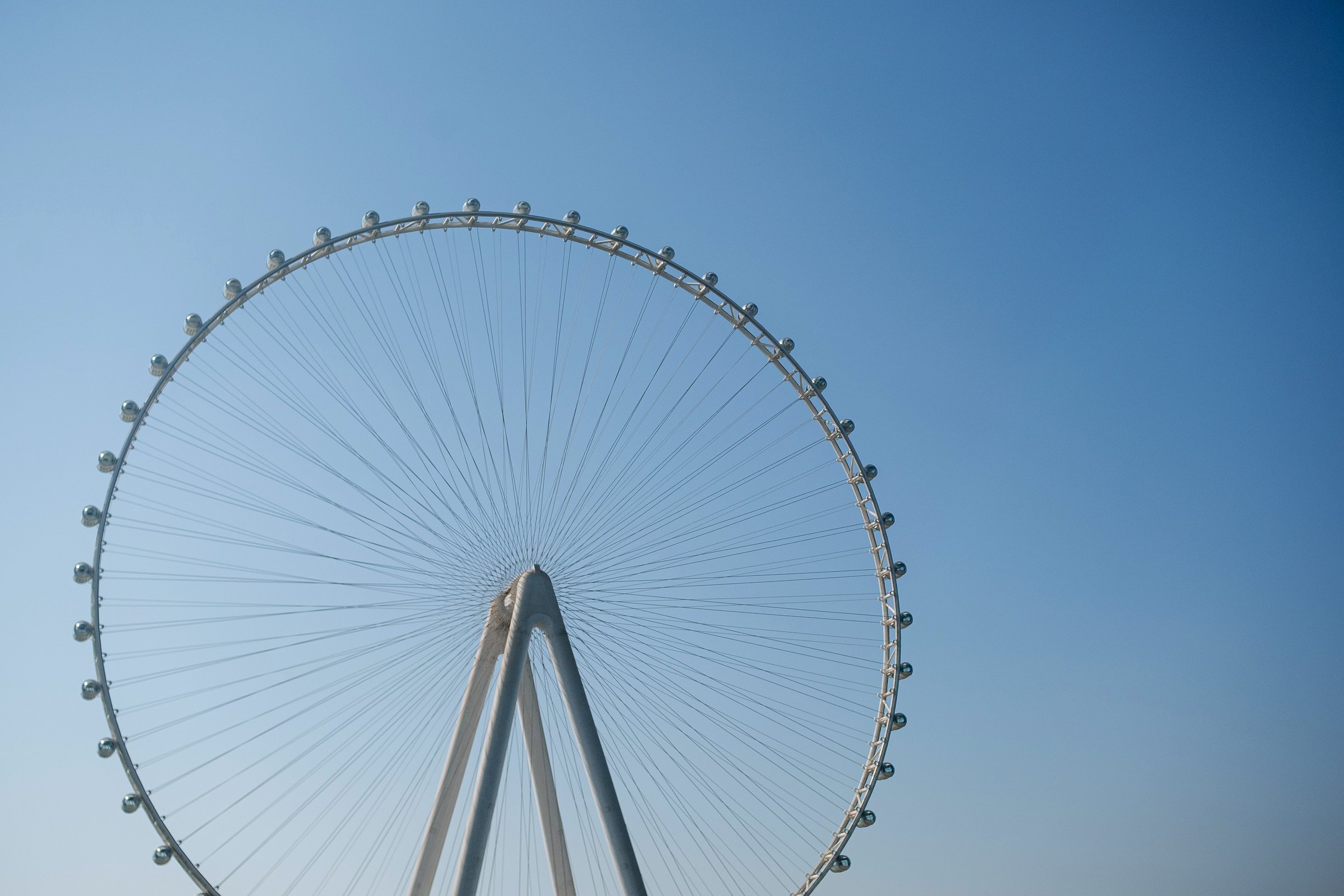 A Ferris wheel against the backdrop of a blue sky and the Persian Gulf. Dubai