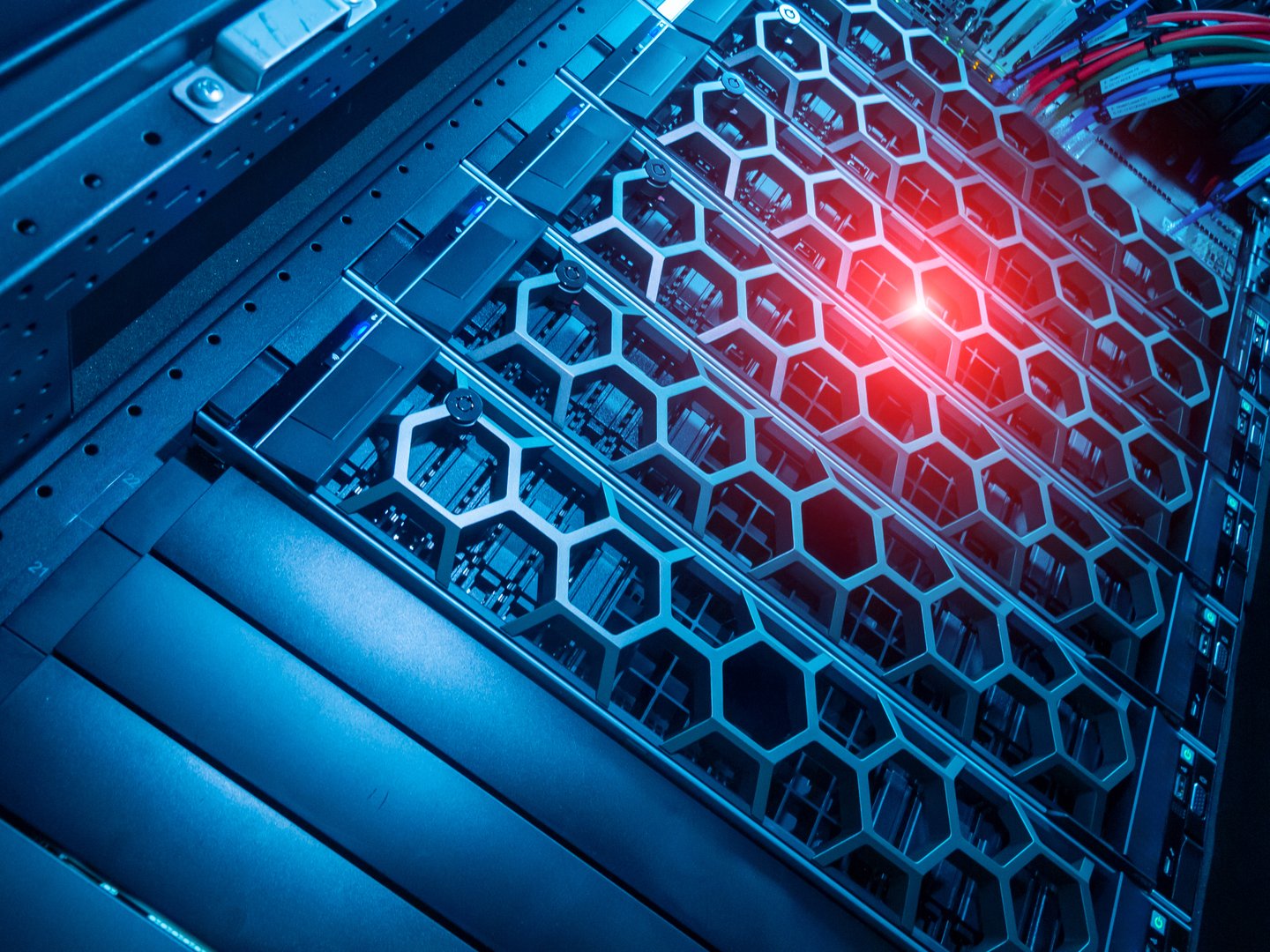 A close-up view of a modern server rack featuring a honeycomb design, illuminated by a cool blue light, showcasing advanced technology in a data center environment.