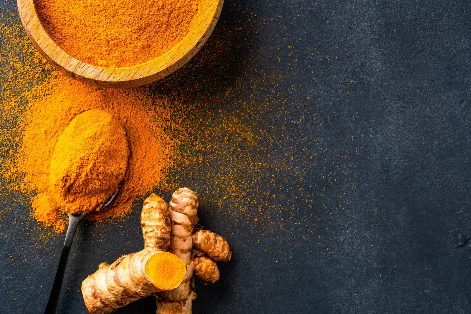 Turmeric with its magnificent orange color on a vintage black background