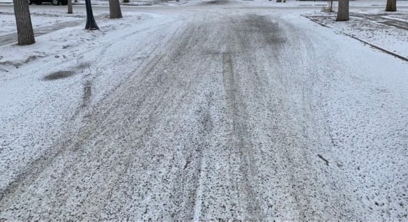 Residential snow clearing service showcasing a cleared driveway and walkway in a snowy Anchorage neighborhood, surrounded by trees and homes.