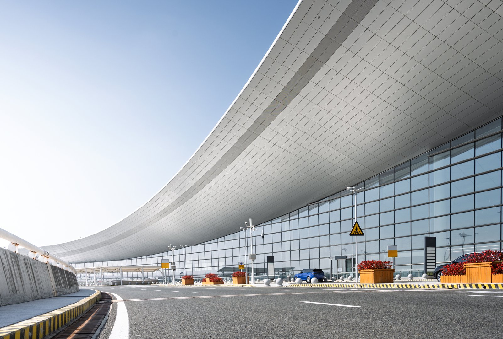 Modern Airport Terminal Building with Curved Roof and Glass Facade Under Clear Sky