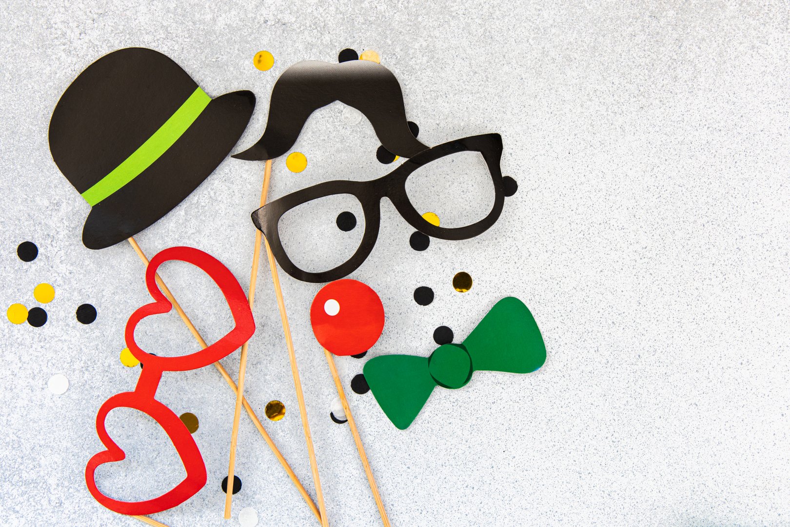 Various playful party props including glasses hats and a clown nose are displayed on a shiny background. Perfect for adding joy to any celebration.