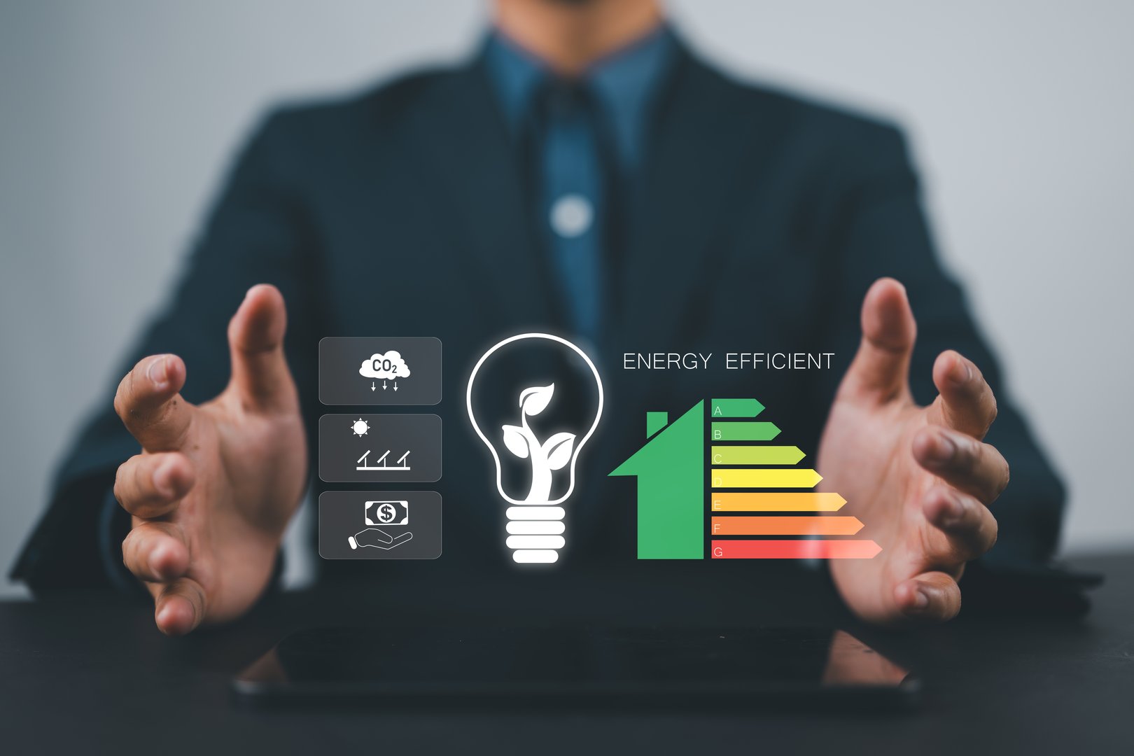 A man holds an electric light bulb with tree inside and an energy saving rating sign to tell customer the value of the product to make a decision. Energy saving and zero co2 clean energy concept.