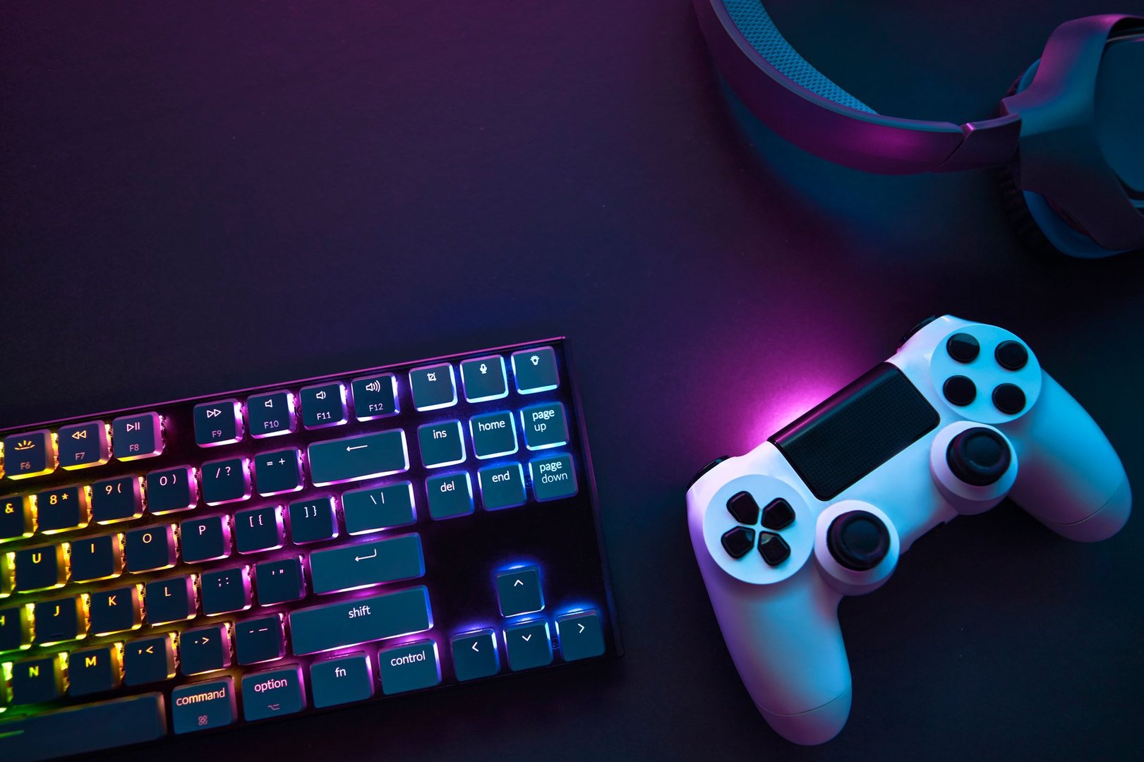 Top down view of colorful illuminated gaming accessories laying on table. Professional computer game playing, esport business and online world concept.