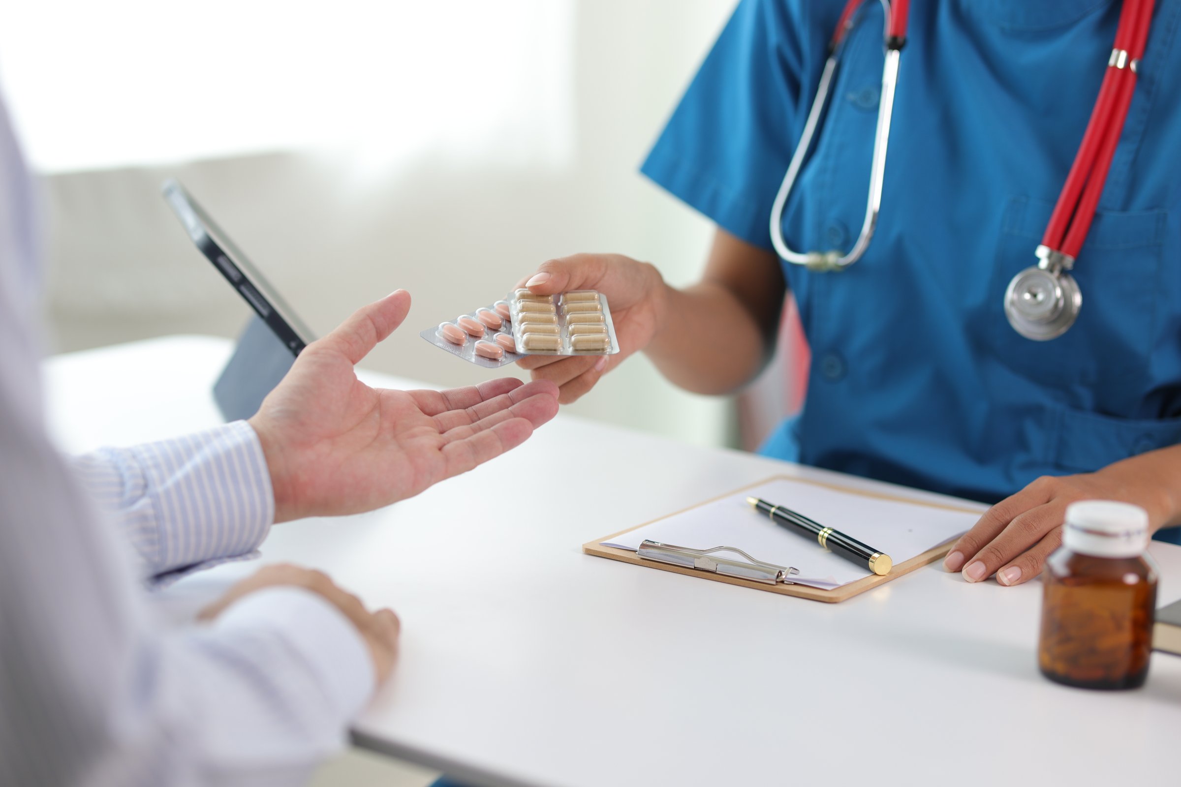 Male patient discussing with female doctor in examination room at hospital. Consultation of health care from a doctor who specializes in medicine from the hospital.