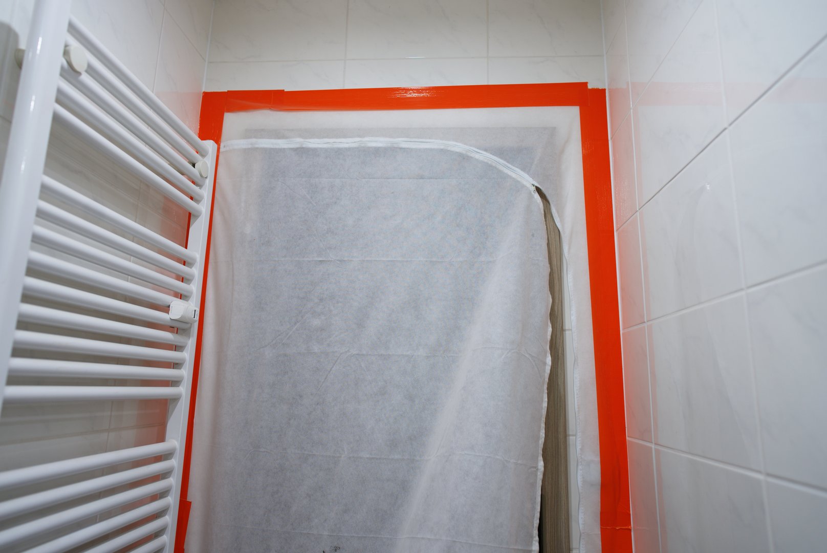 A bathroom restoration is underway with protective coverings and safety measures in place for optimal results