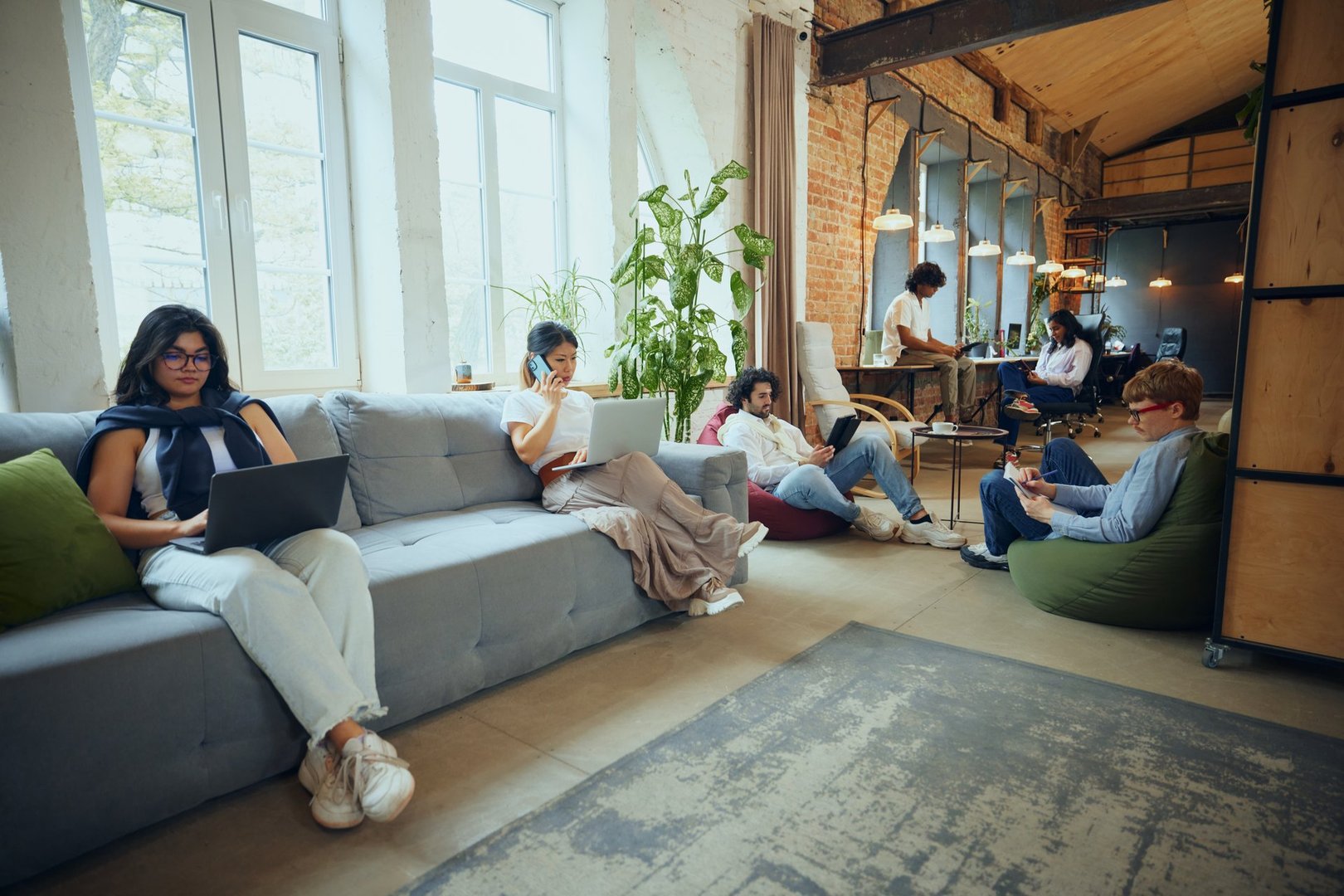 Dynamic workday. Young multiethnic people meeting in co-working environment, showing bustling activity that characterizes modern workspaces. Concept of business and education, co-working space