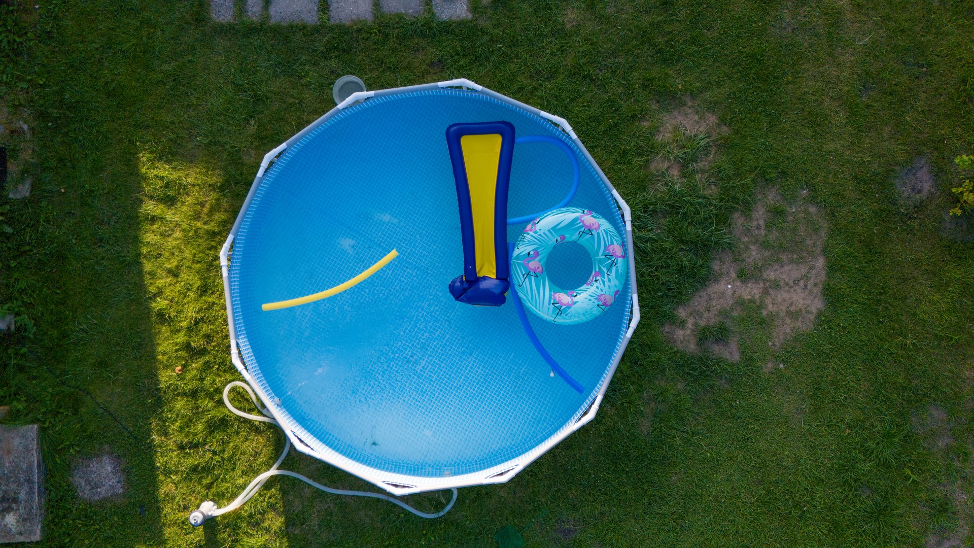 Aerial View of Backyard Pool with Inflatable Toys