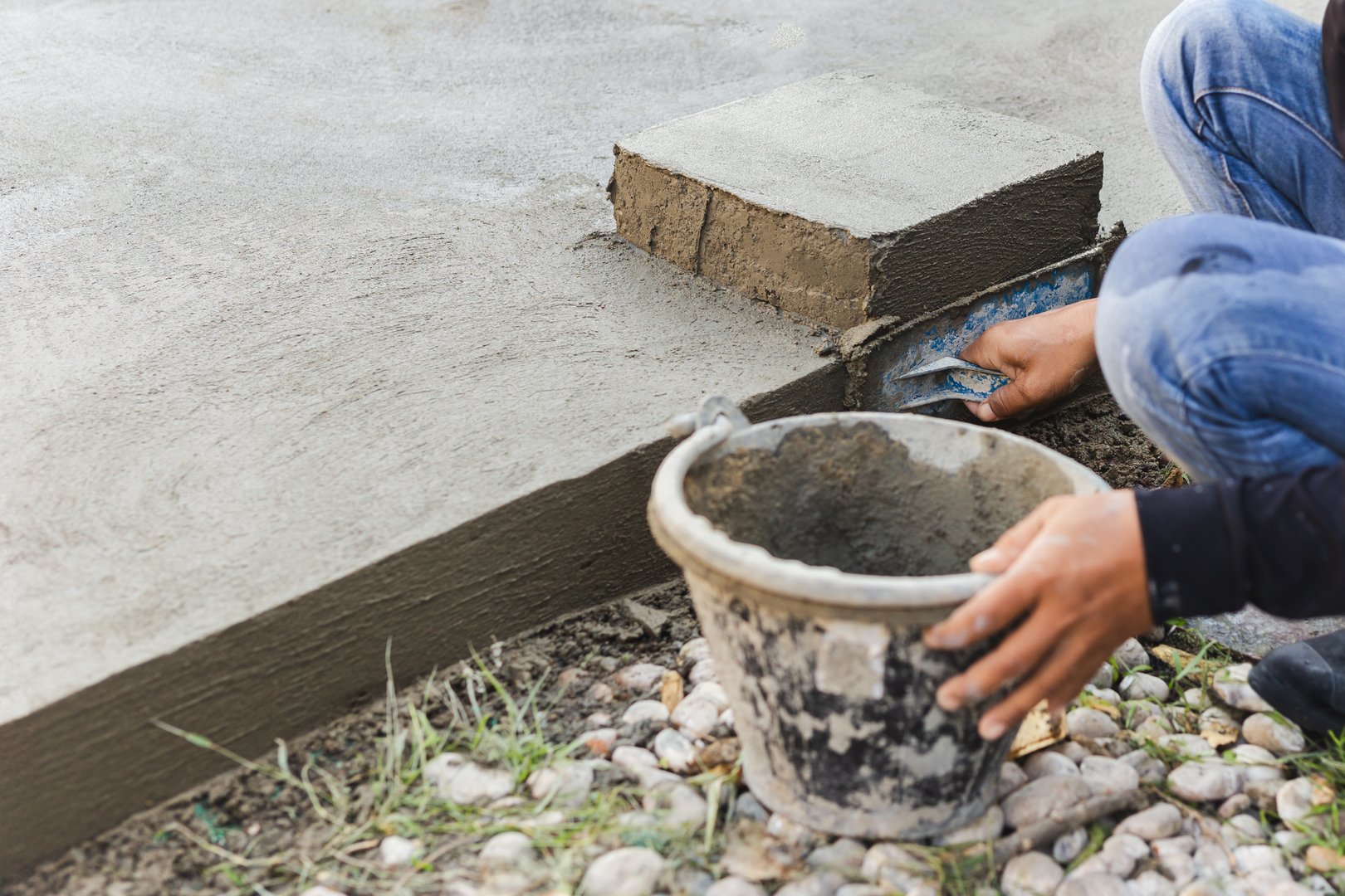 Worker leveling concrete cement floor using trowel
