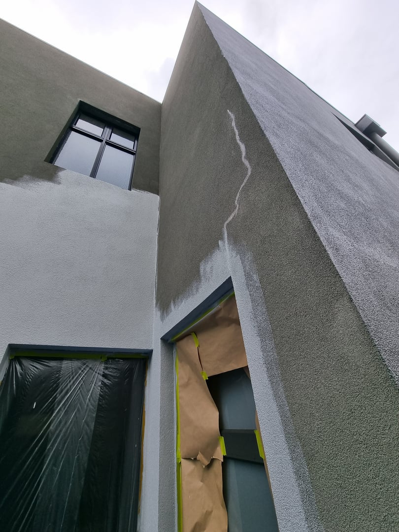 Rendered cladding before restoration showing weathered exterior