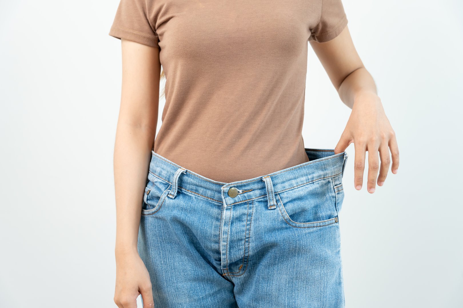 Women showing results of diet. Beautiful shape. female have a reduced waist size after under going a weight loss corse. can not wear jeans due to weight loss. balance, control, routines, exercise.