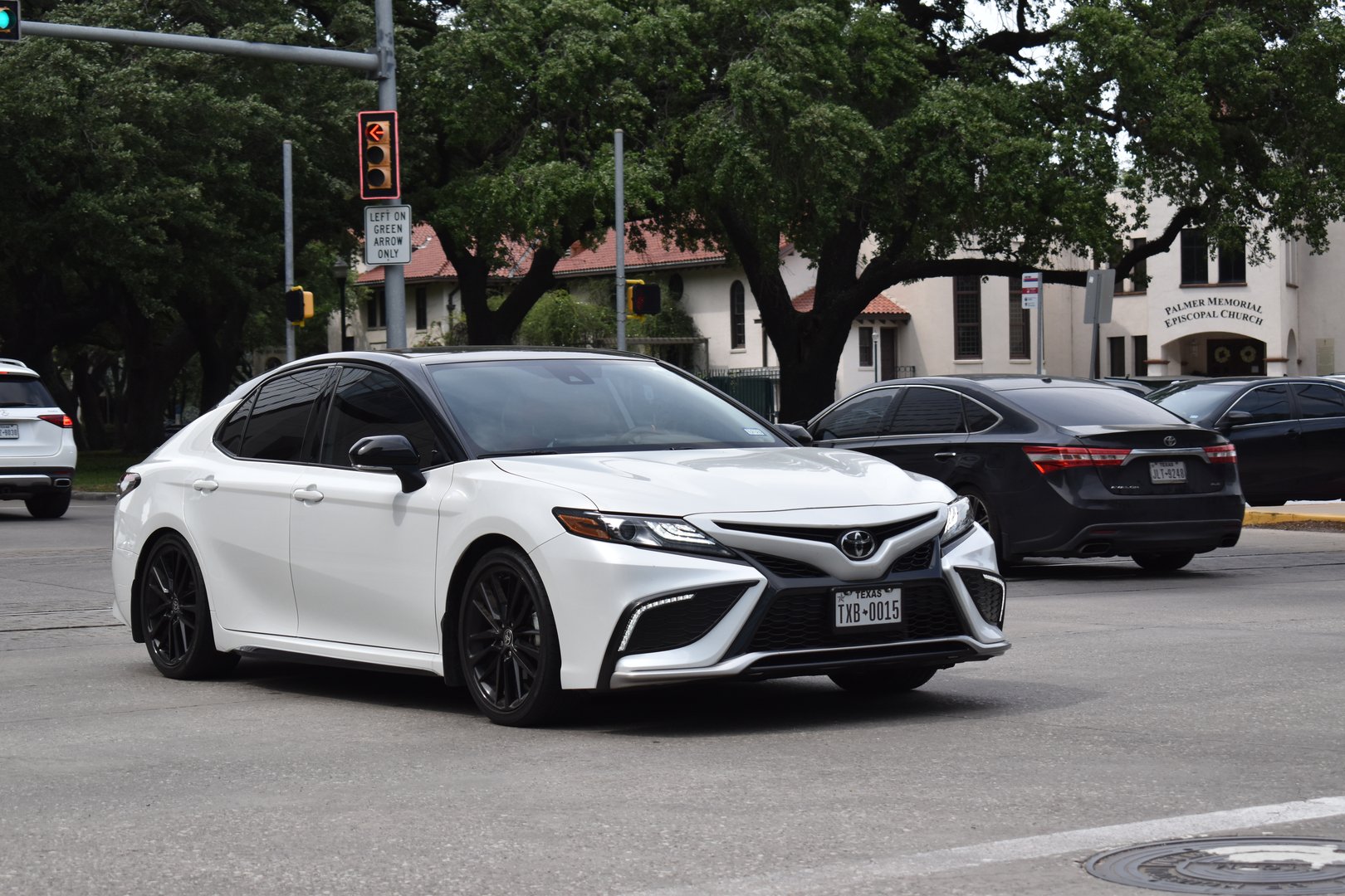 Houston, TX USA - 4-18-2025 - A portrait of a white Toyota Camry sedan traveling down a highway in moderate traffic