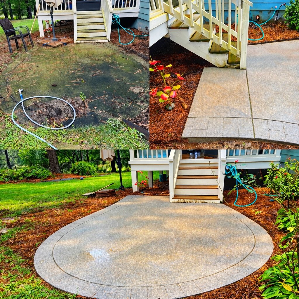A worker using a surface cleaner to pressure wash a concrete sidewalk with grass on the side.