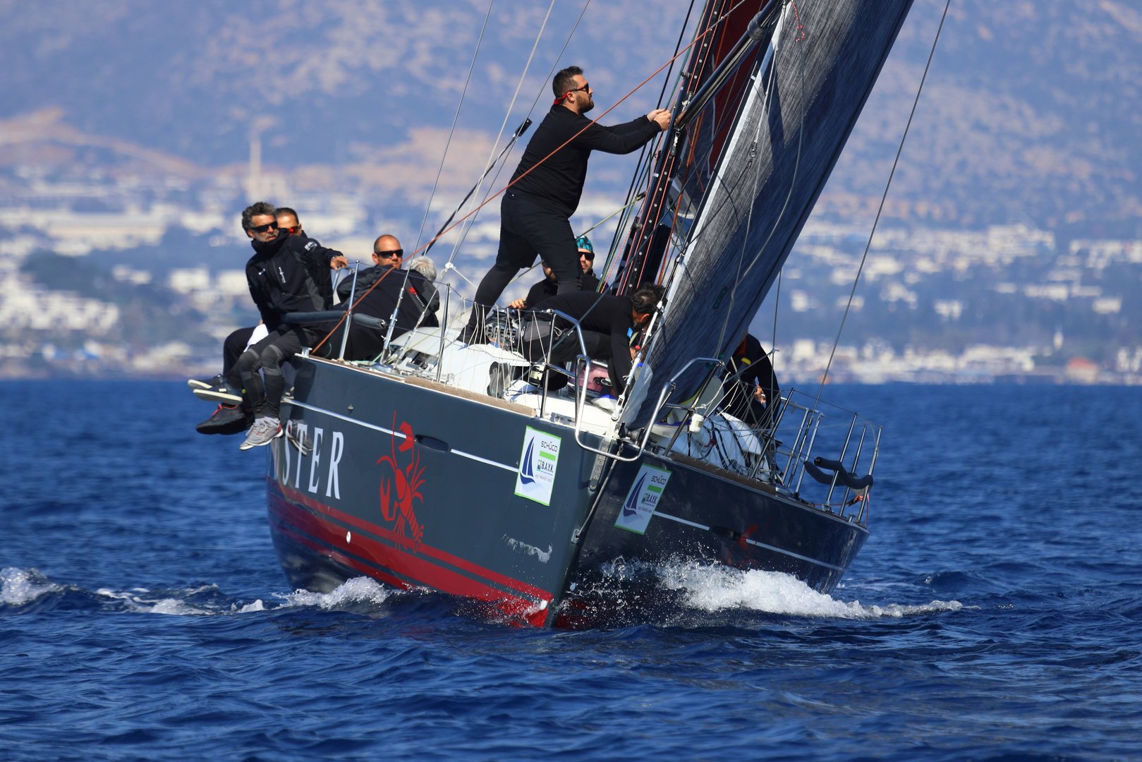 Bodrum,Turkey.   March 08, 2025: Sailboats sail in the blue waters of the Aegean Sea in windy weather on the coast of the famous holiday resort of Bodrum. Boat owners have a pleasant weekend with their sails in the town, where the winter months are warm.