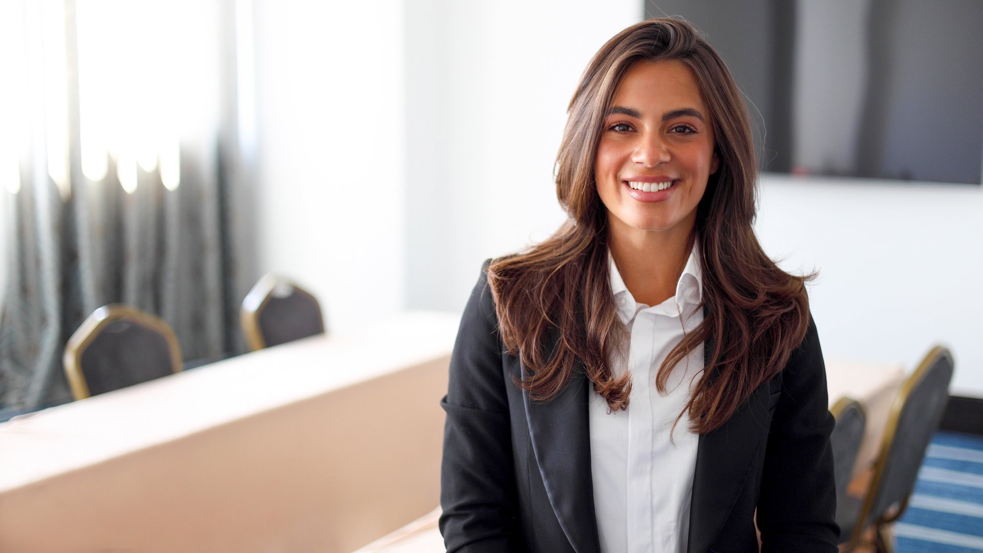 Portrait of a beautiful, young businesswoman posing at the boardroom before a business conference