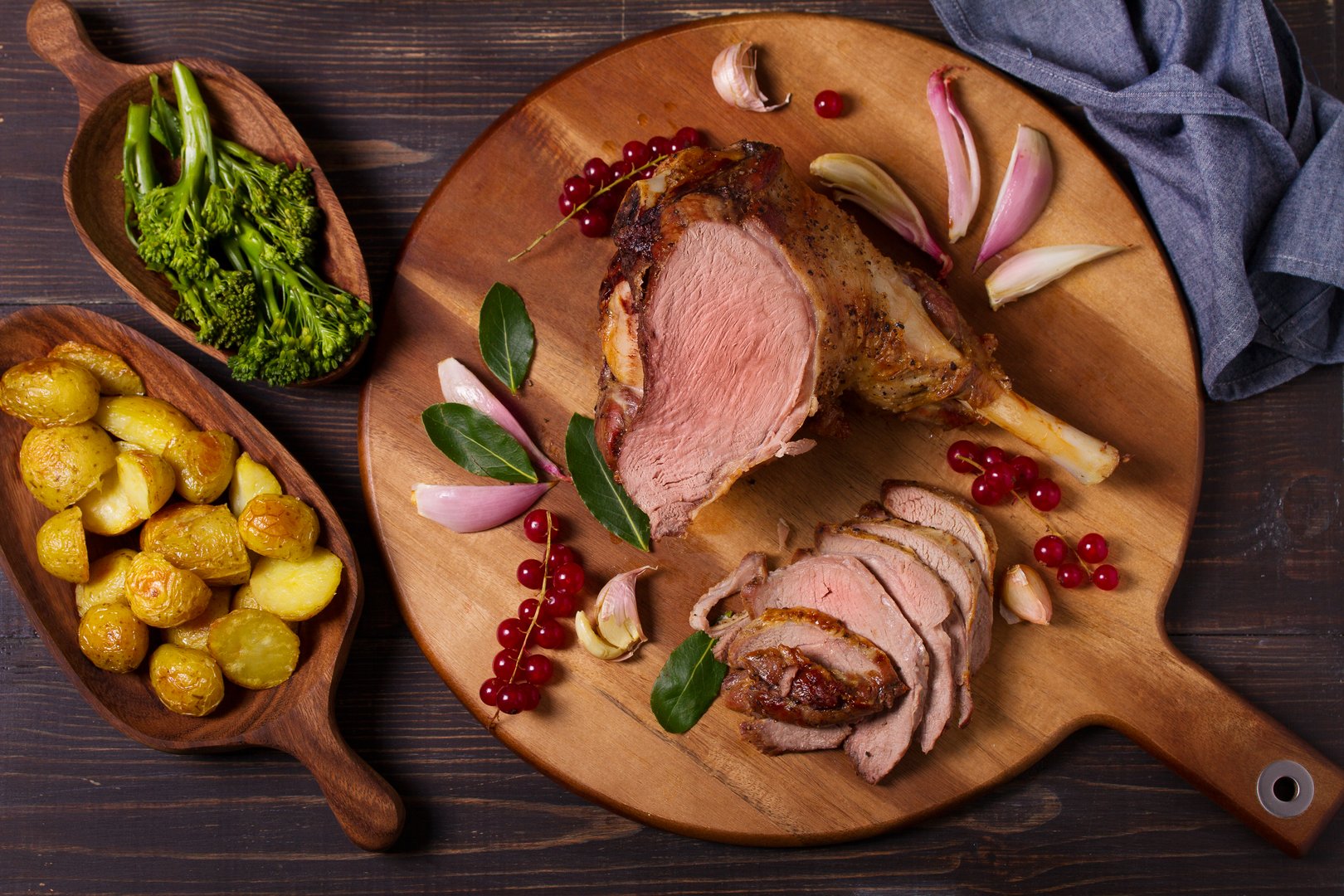 Roasted leg of lamb on serving board. High angle view