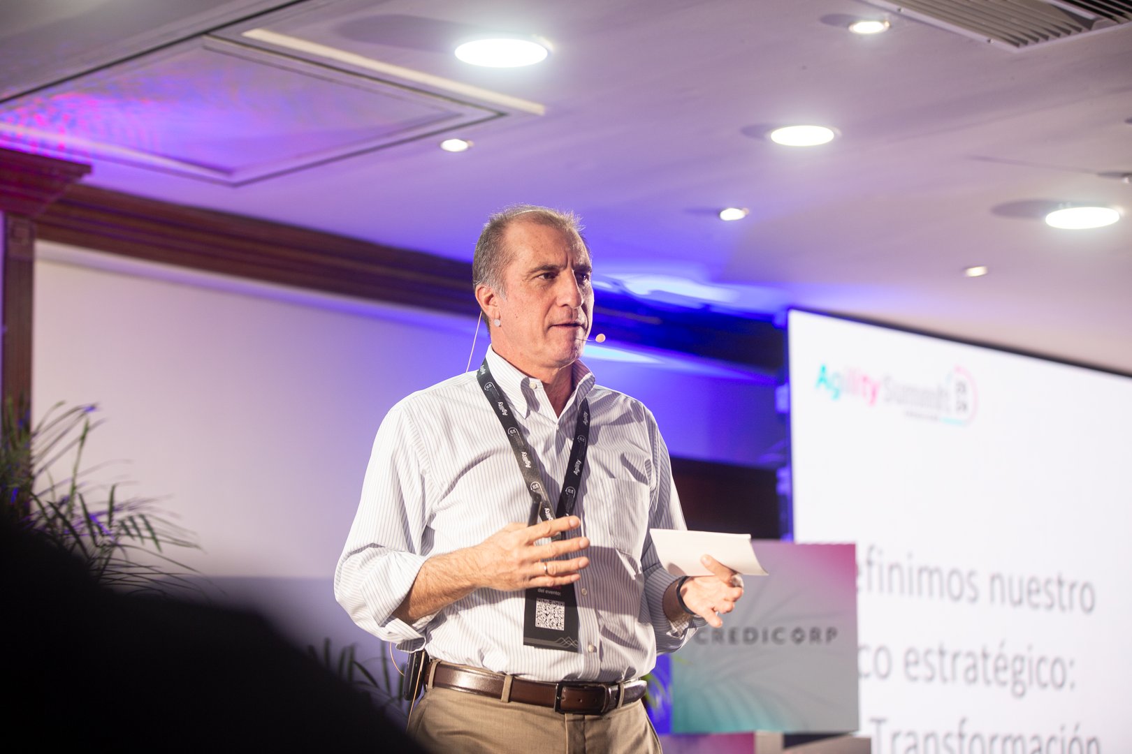 Portrait of happy businessman sitting at office desk, looking at camera, smiling