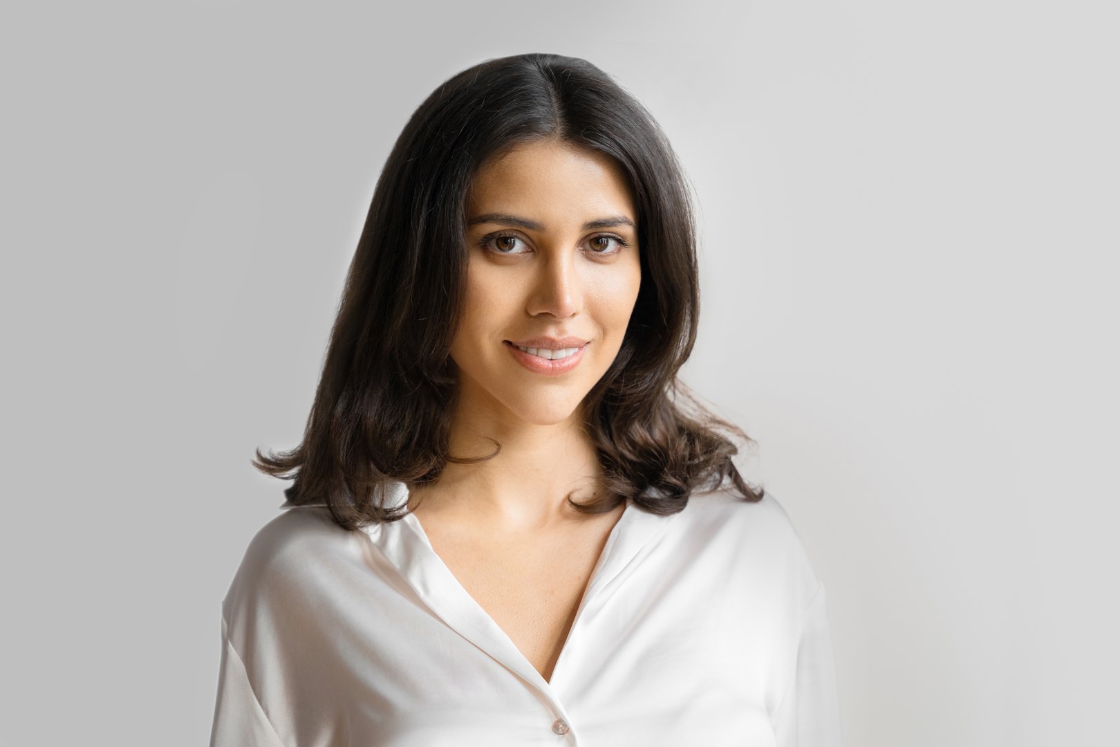 Headshot closeup portrait middle eastern Israel businesswoman, business lady standing isolated on white background. Happy smiling young successful 20s Arabian or Indian woman in suit, looking camera