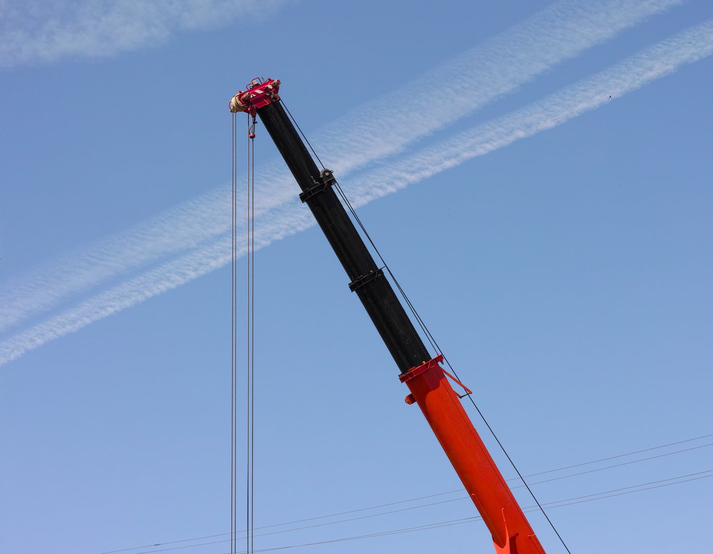 Close-up of construction crane boom against a blue sky